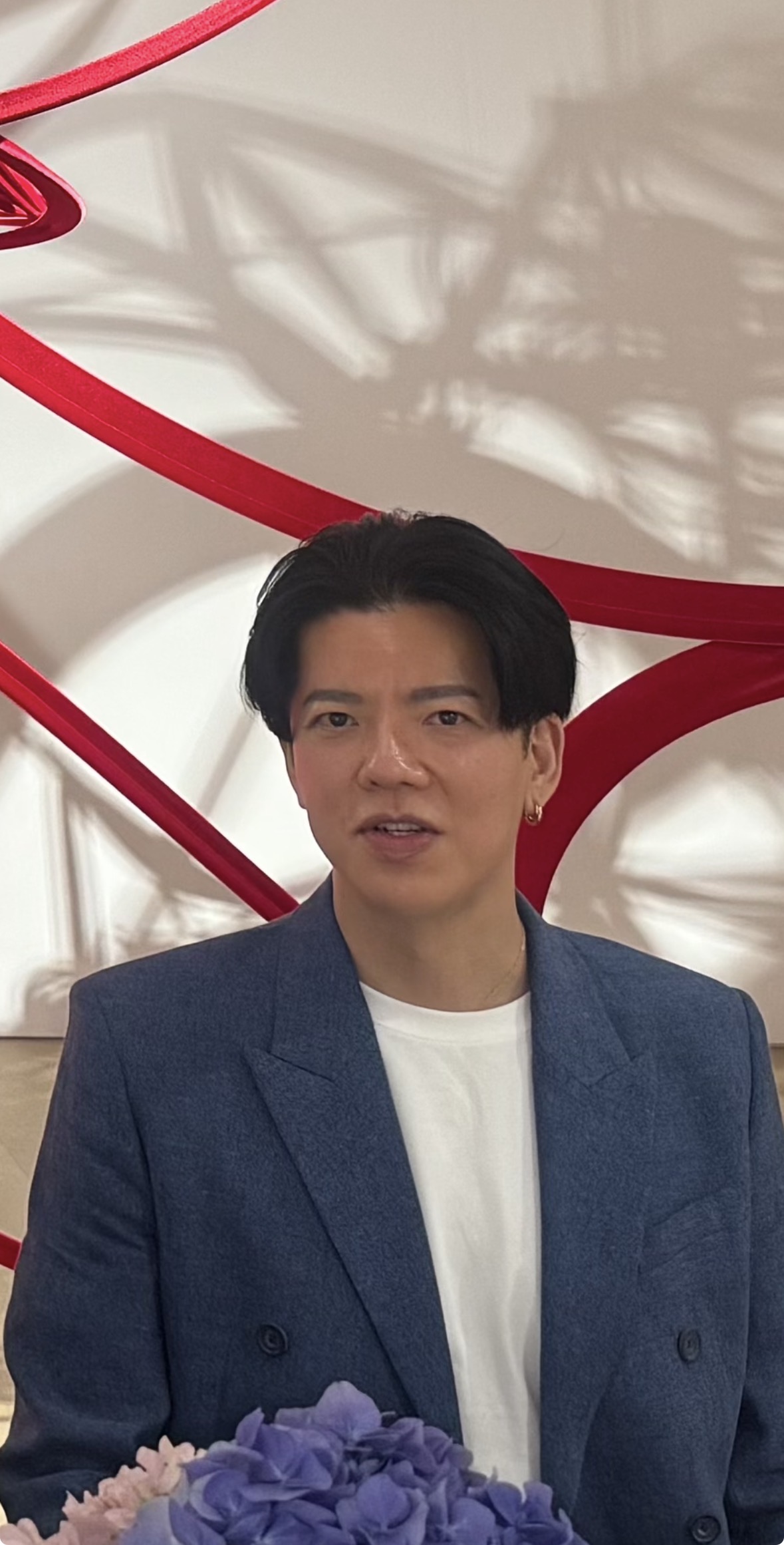Hiroaki Ikeda in front of a work by Ryunosuke Okazaki