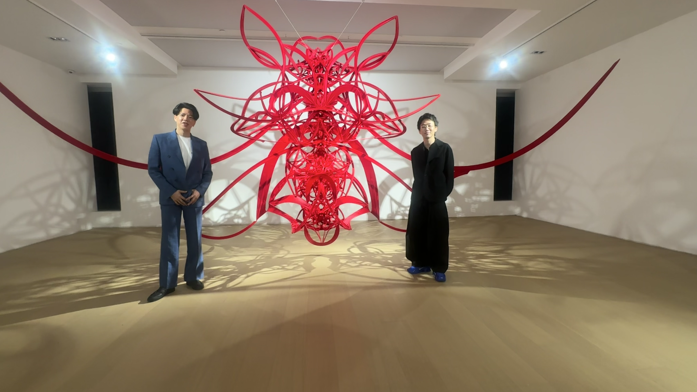 Hiroaki Ikeda and Ryunosuke Okazaki in front of an artwork